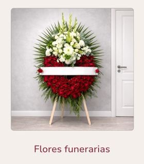 Flores para funeral Corona funeraria de rosas rojas y cabecero de flores blancas sobre soporte.