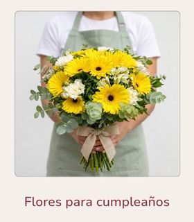 Flores para cumpleaños Ramo de flores variadas en tonos blancos y amarillos sostenido con ambas manos